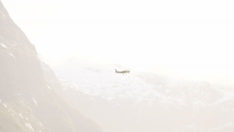 plane flying over the milford sound through the fog in new zealand