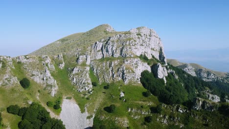 aerial of stunning rock formations on the mountain peak and the edge of the forest at sunrise