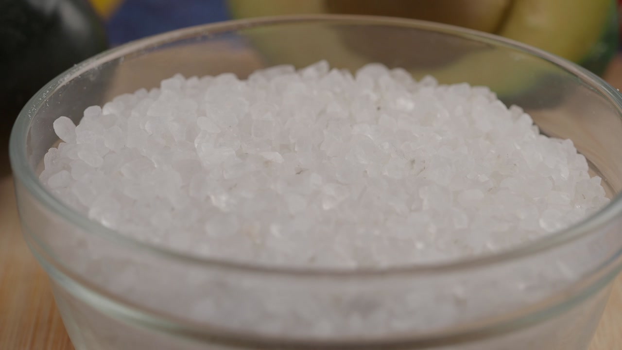 Close-up of White Coarse Salt Crystals in a Glass Bowl