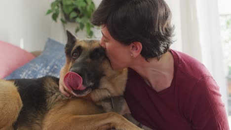 primer plano de una mujer caucásica jugando con su perro en la sala de estar en casa