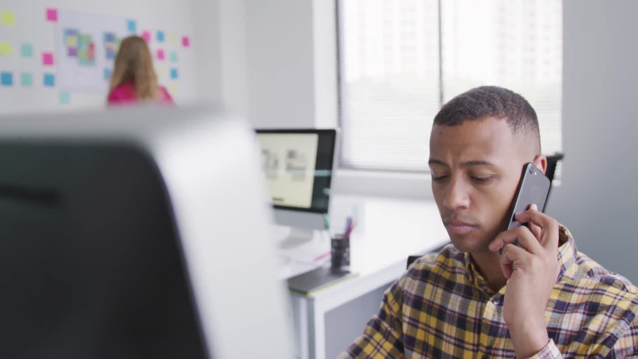 Mixed race man calling in front of computer