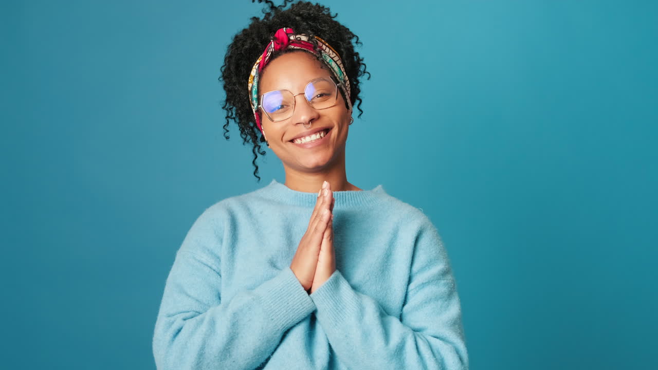 Young Woman Smiling and Making Namaste Gesture