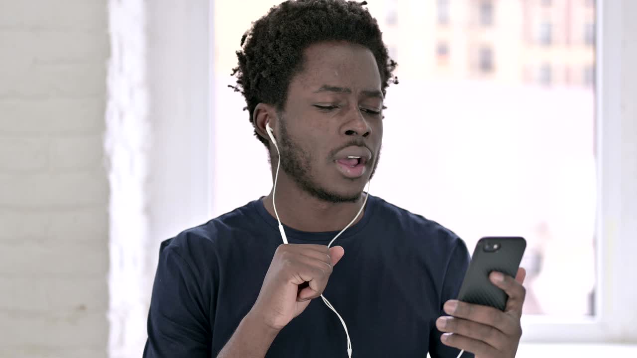 retrato de un joven afroamericano escuchando música con auriculares
