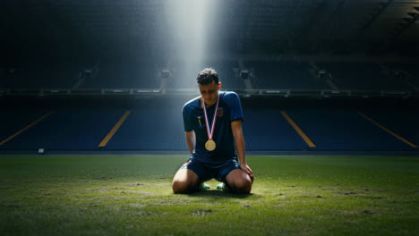disappointed soccer player kneeling on grass