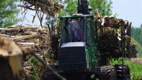 a bokeh shot capturing forest machinery in slowmo as it unloads cut wood from a trailer to the ground. the blurred background enhances the focus on the machinery, creating a dynamic, cinematic scene.