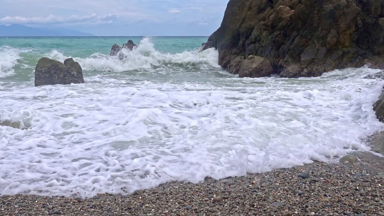vista en cámara lenta de las olas que salpican contra las rocas en la playa de banbanon en surigao del norte en filipinas