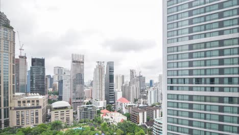 Timelapse-glass-skyscraper-building-with-cloudy-sky-timelapse-in-the-background-in-summer-daytime