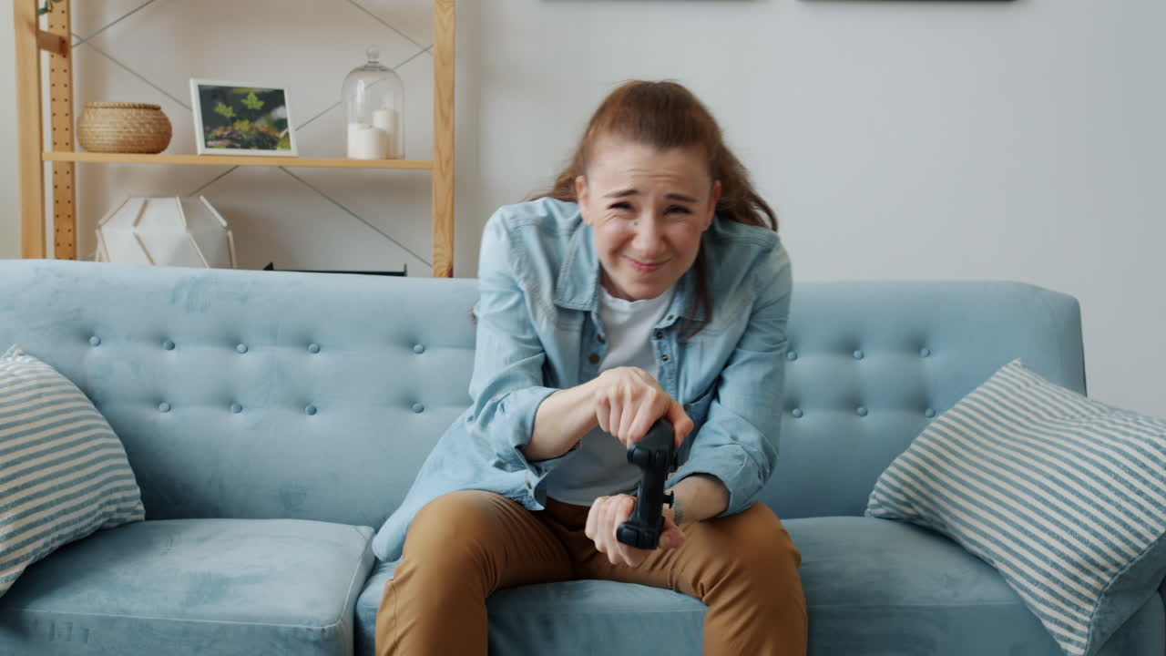 소파에서 비디오 게임을 하는 여자