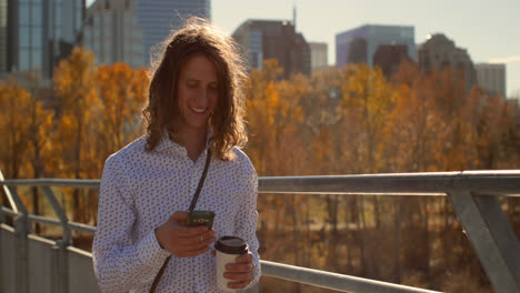 Vista-Frontal-De-Un-Joven-Caucásico-Usando-Un-Teléfono-Móvil-En-El-Puente-4k