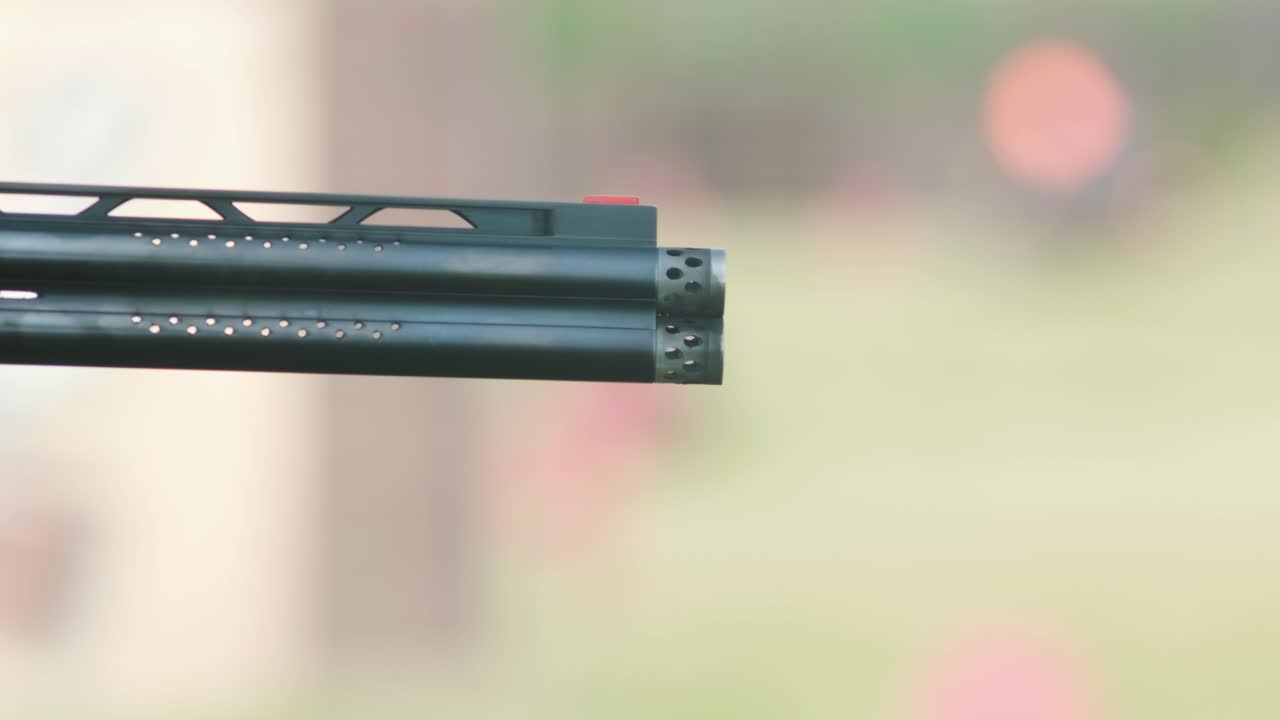 un deportista dispara con una escopeta de doble cañón, un campo deportivo para una prueba de tiro está disparando a un esquete volador