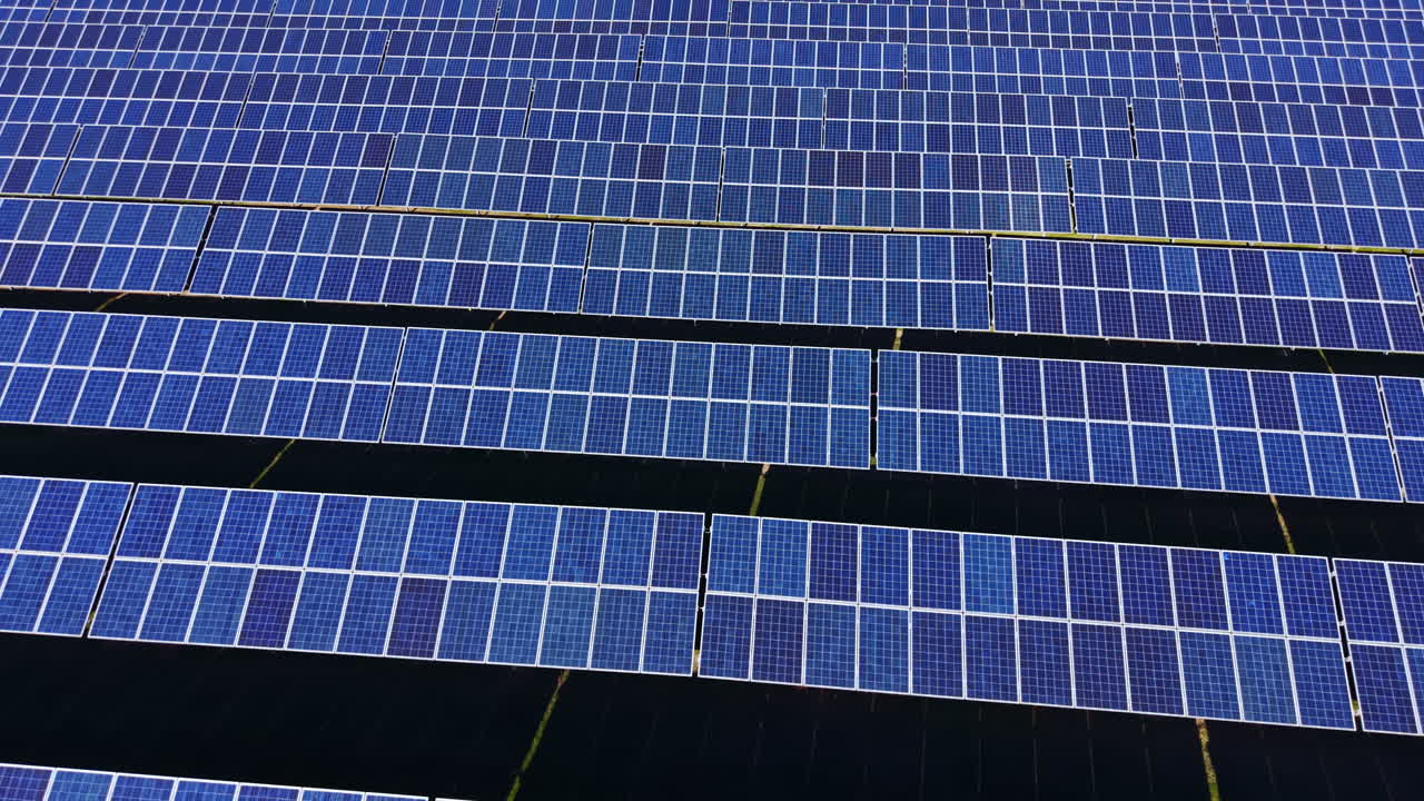 File di pannelli solari in un vasto campo che sfruttano la luce solare per la produzione di energia.