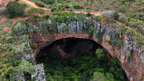 Dron-Aéreo,-Muñeca-Mediana,-En-Una-Toma-De-La-Gran-Entrada-De-La-Cueva-De-Lapa-Doce-De-Rocas-Coloridas-Con-Una-Selva-Tropical-Autónoma-Debajo-En-El-Parque-Nacional-Chapada-Diamantina-En-Bahia,-Noreste-De-Brasil