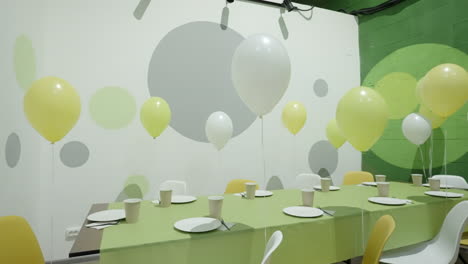 party room decorated with balloons and table settings