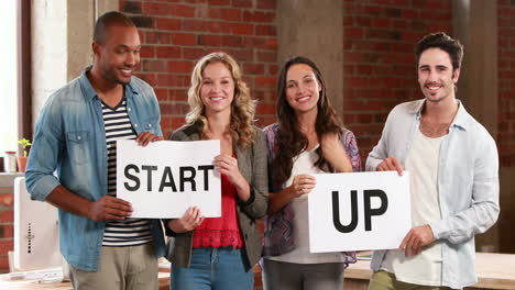 casual business team holding start up signs