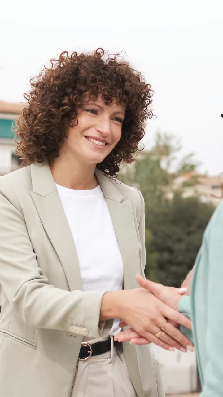 Businesswoman shaking hands greeting new partner. Vertical
