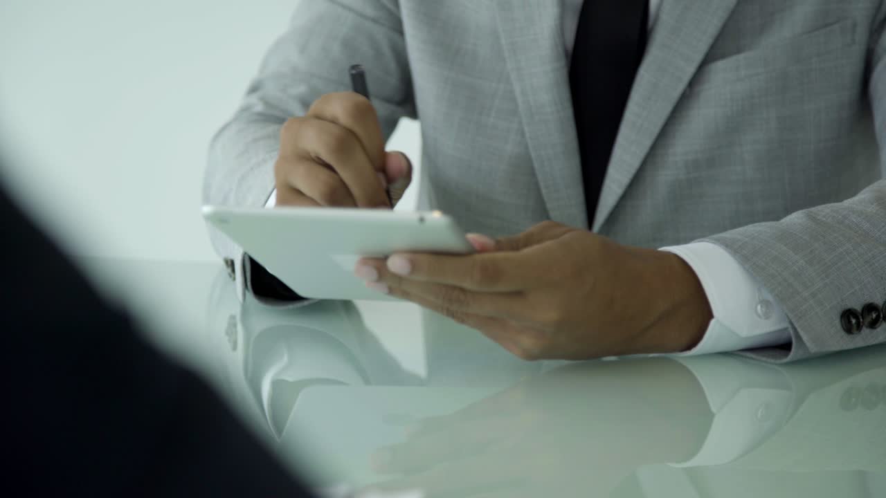 Cropped shot of young man signing electronic documents.