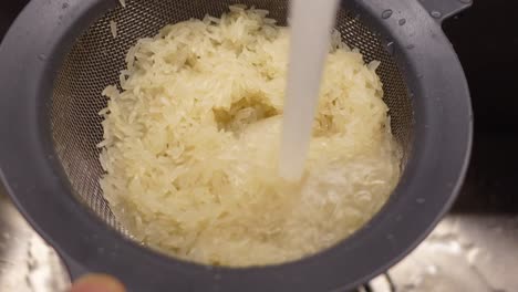 washing rice in a colander