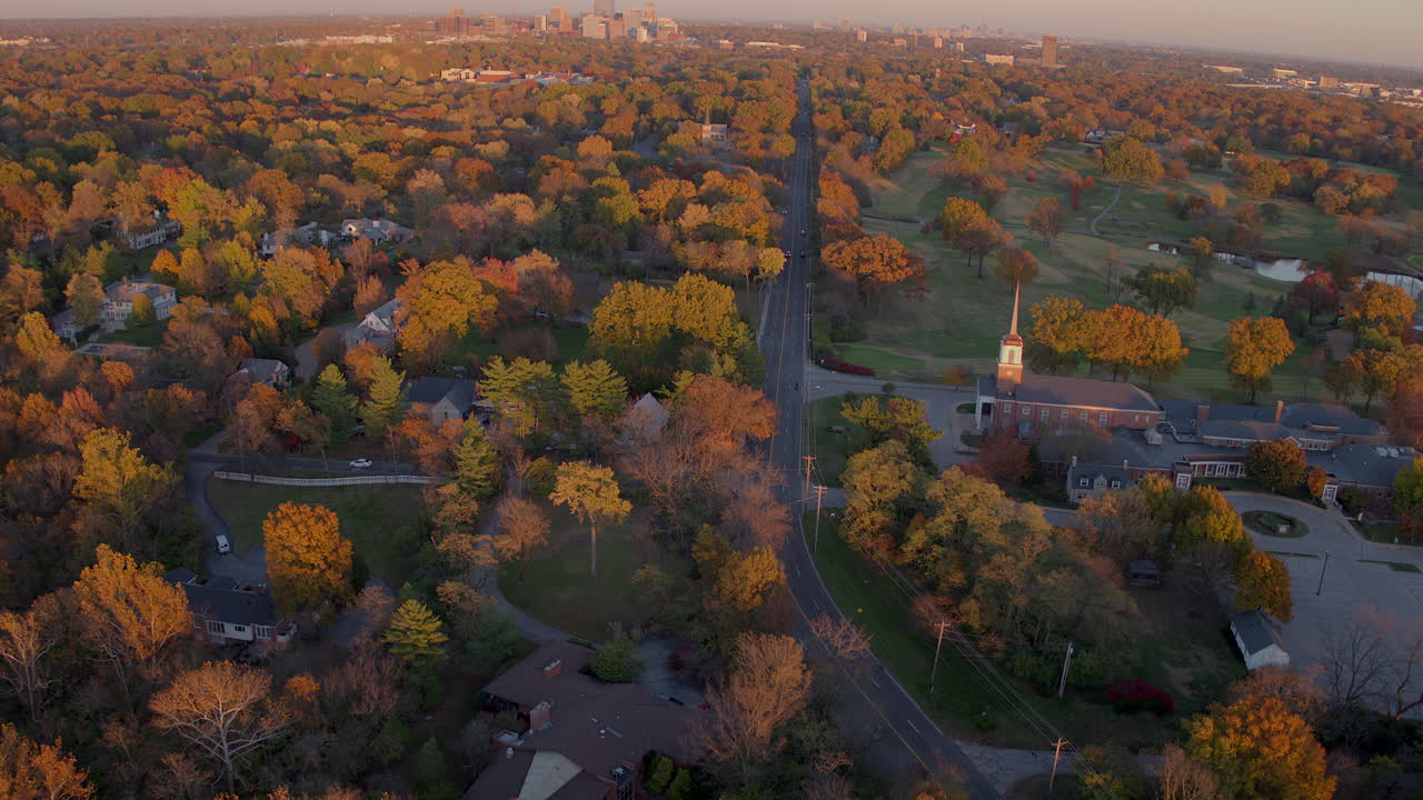antena del encantador paisaje de ladue en el otoño en color máximo con clayton rd y una pequeña iglesia con una inclinación hacia arriba para revelar el horizonte de la ciudad de clayton en el horizonte en un hermoso día de otoño