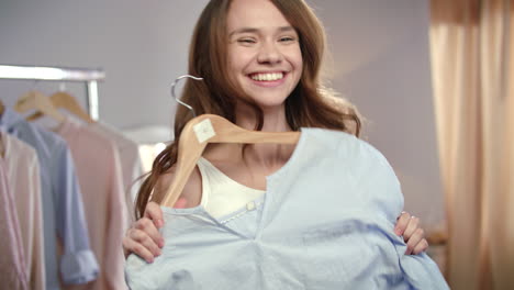 young woman trying clothes at wardrobe