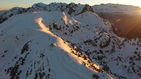 Ski-resort-summit-track-at-Chamrousse-in-the-French-Alps-with-shelter-cabin-and-ski-lift-line,-Aerial-orbit-left-shot