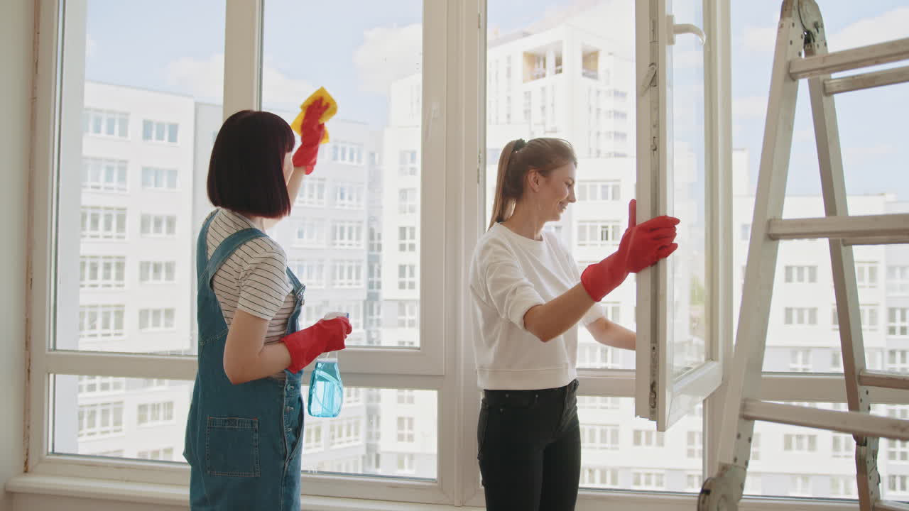 두 명의 여성이 창문을 청소하고 있습니다.