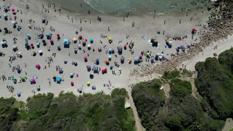 sumérgete en la belleza costera de la playa de llandudno, ciudad del cabo, con imágenes diurnas de drones sobre vibrantes sombrillas de playa