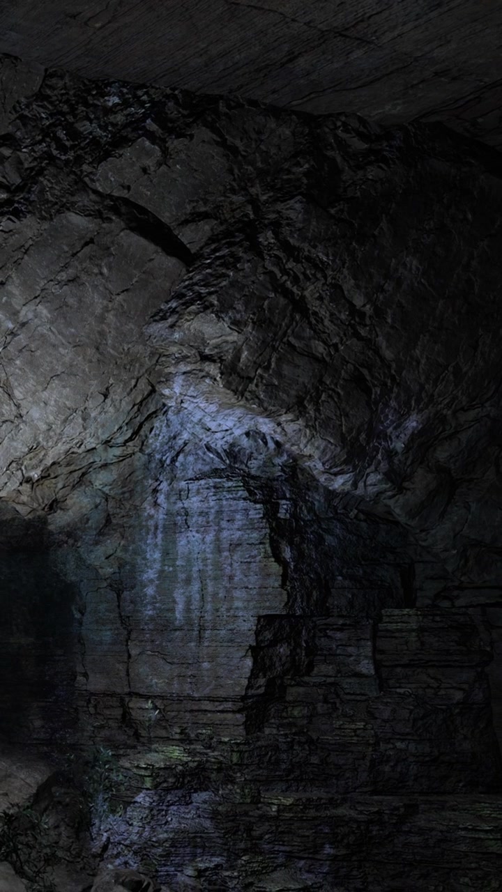 L'acqua scorre su una superficie rocciosa in un ambiente di grotta buia di sera