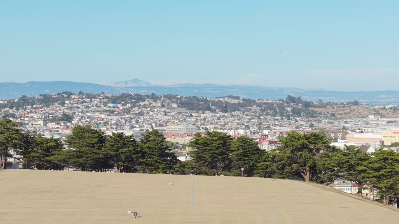 The neighborhood's rooftops form a mosaic of textures and colors under shifting coastal clouds.