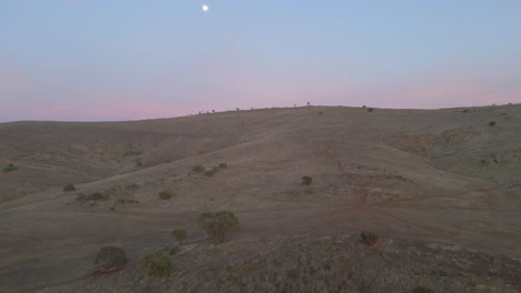 vuelo aéreo hacia las colinas de appila springs que revela un paisaje campestre interminable, puesta de sol con luna
