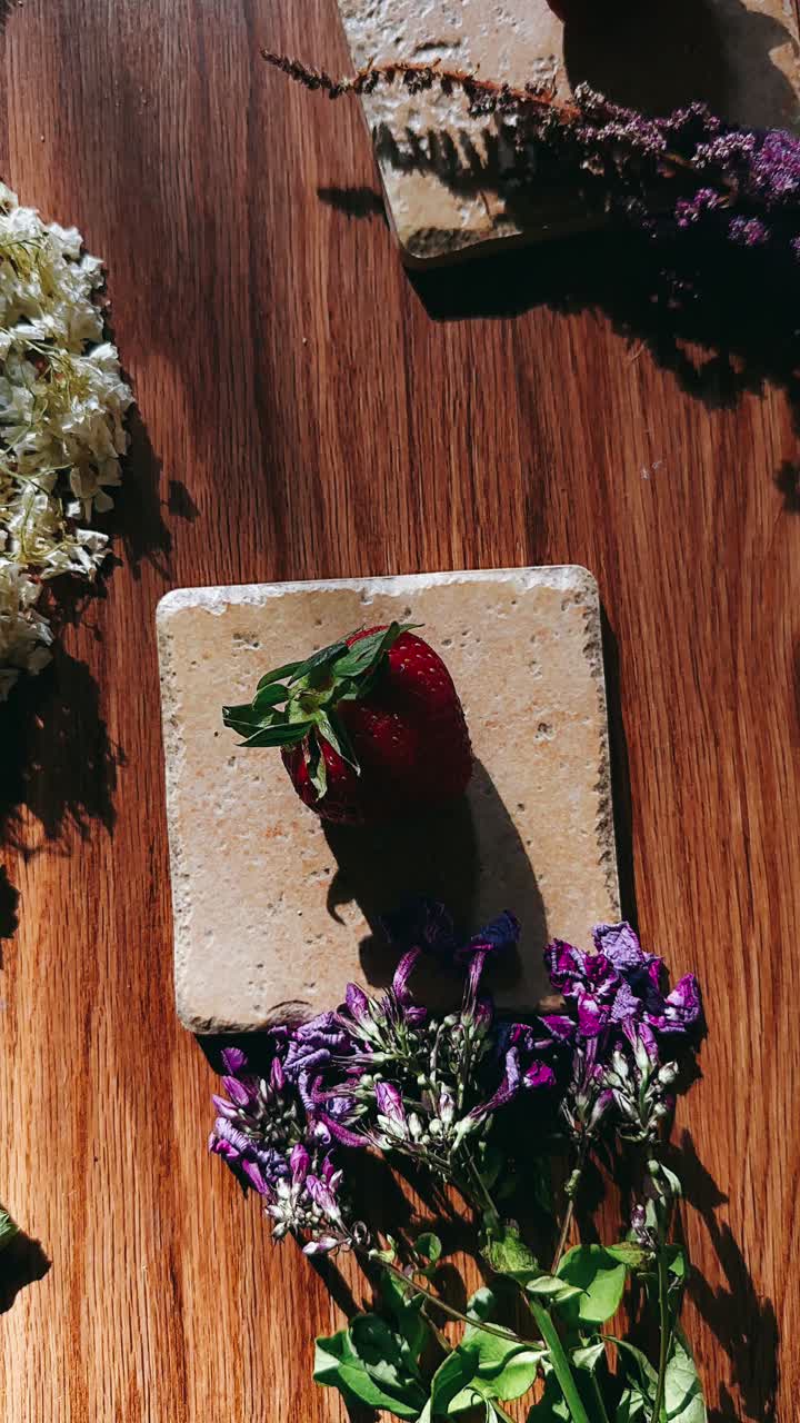fresas y flores en una mesa de madera