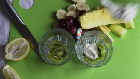 yogur griego fresco encima de rodajas de kiwi verde con piña y uvas