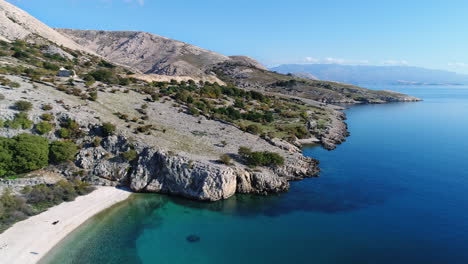 Antena-De-Una-Hermosa-Playa-Escondida-Entre-Montañas-En-La-Costa-De-Croacia-Cerca-Del-Pueblo-De-Baska