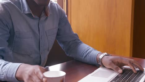 attractive man using laptop and drinking