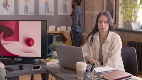 pregnant woman sitting at table talking with a coworker in a meeting room 1