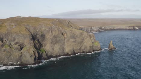 aerial view of rocky coastline with ketubjorg cliffs during sunny day on iceland - backwards movement flight