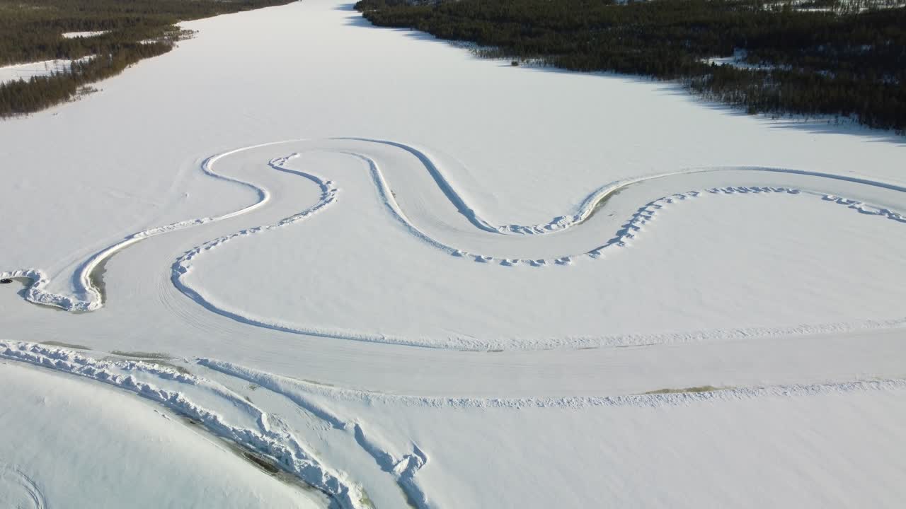 Whole Race track on a Frozen Lake in Finland during golden hour – Aerial Winter Landscape high altitude top down
