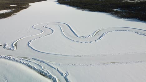 whole race track on a frozen lake in finland during golden hour – aerial winter landscape high altitude top down