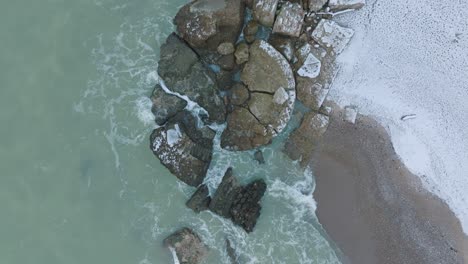 aerial birdseye view of abandoned seaside fortification buildings at karosta northern forts on the beach of baltic sea , overcast winter day, drone shot moving forward