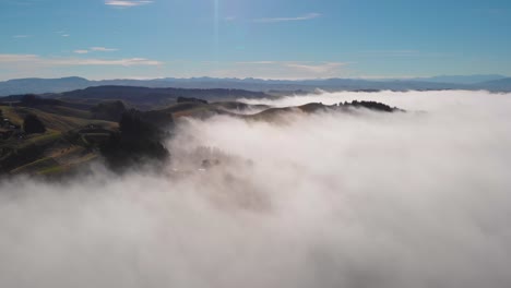 slowly flying above a dreamlike panorama of rolling hills in an ocean of clouds