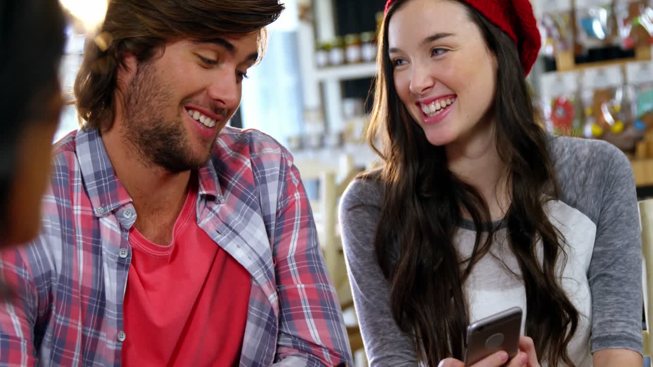 hombre y mujer sonrientes interactuando por teléfono móvil