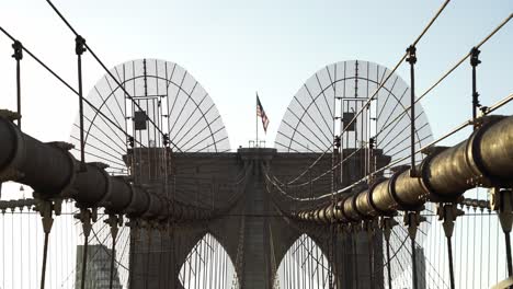 commuters crossing brooklyn bridge in new york on a sunny evening