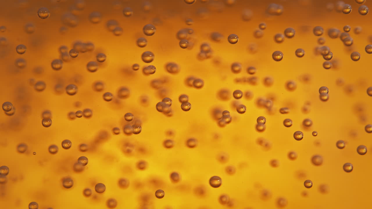 Air Bubbles Moving In Orange Liquid - Light Beer In Macro And Slow Motion