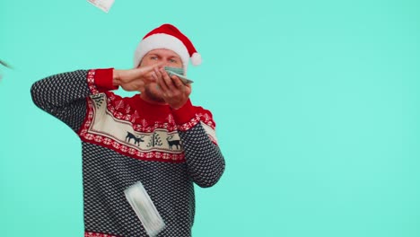 rich man winner in christmas red sweater and hat showing wasting, throwing money around, shopping