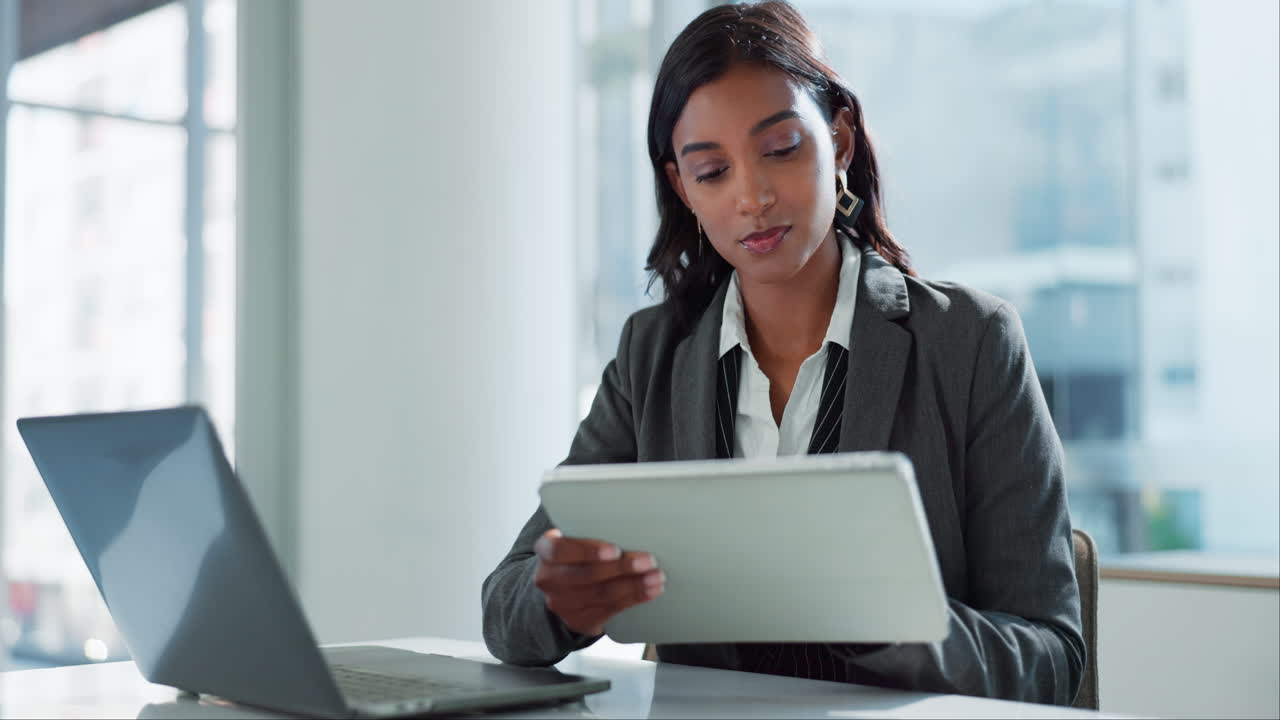 Businesswoman working on tablet and laptop in office