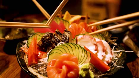 chopsticks picking sashimi from a colorful platter