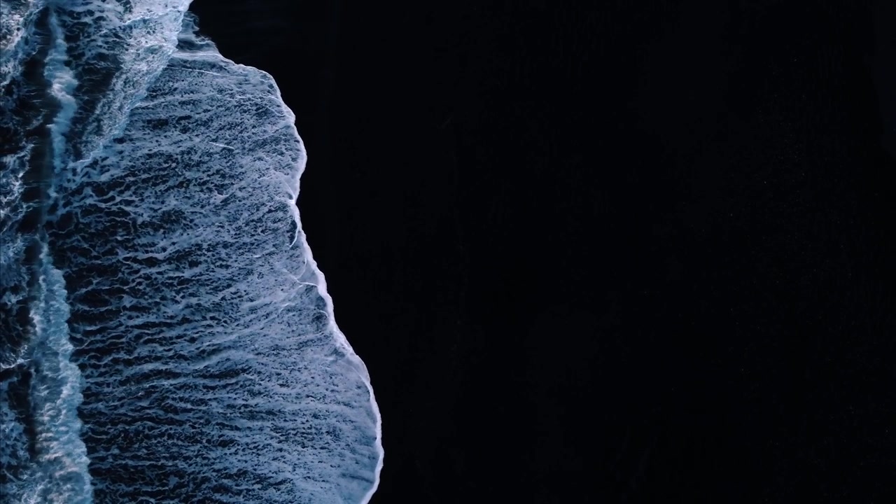 Experience the mesmerizing power of waves crashing on the dark, volcanic sands of Reynisfjara Beach in Iceland.