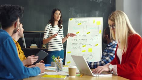 young woman explaining business strategy and development to young multicultural entrepreneurs group in a meeting the office