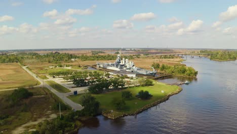 drone orbit over a navy ship docked on a river in south carolina