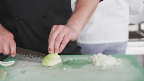 chef caucásico cortando verduras en la cocina, en cámara lenta