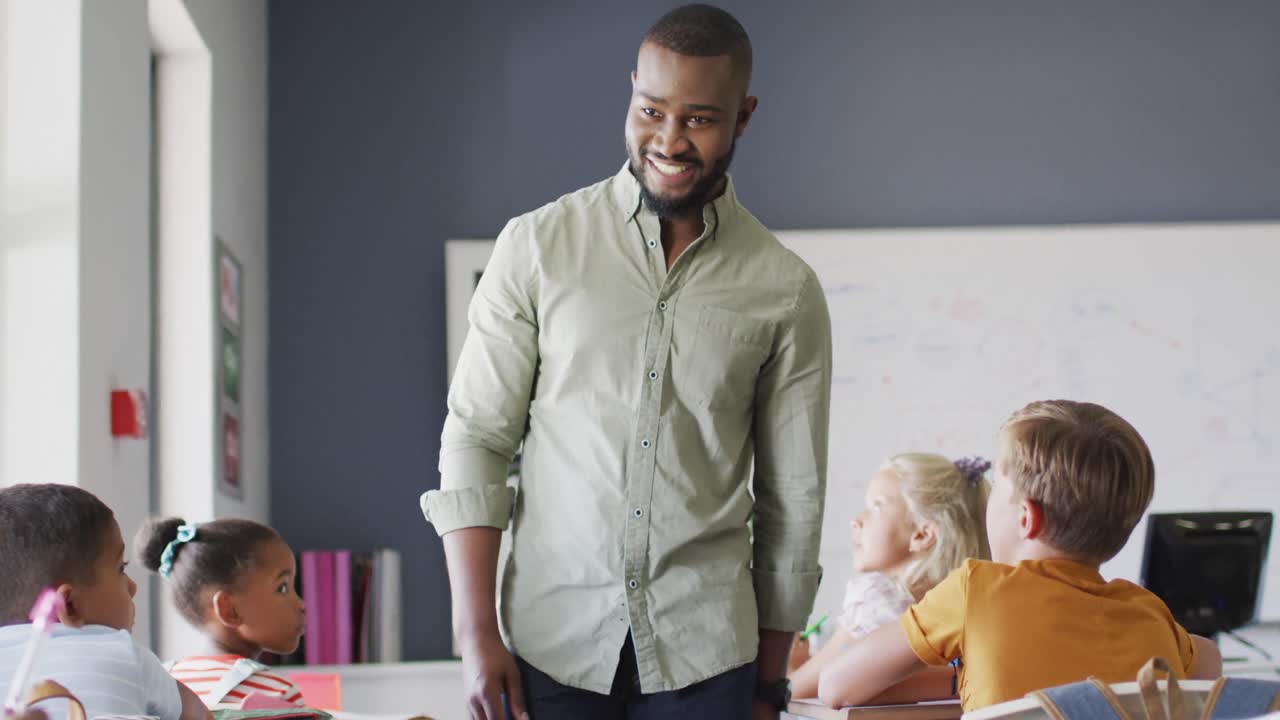 video de un feliz maestro afroamericano durante la lección con una clase de alumnos diversos